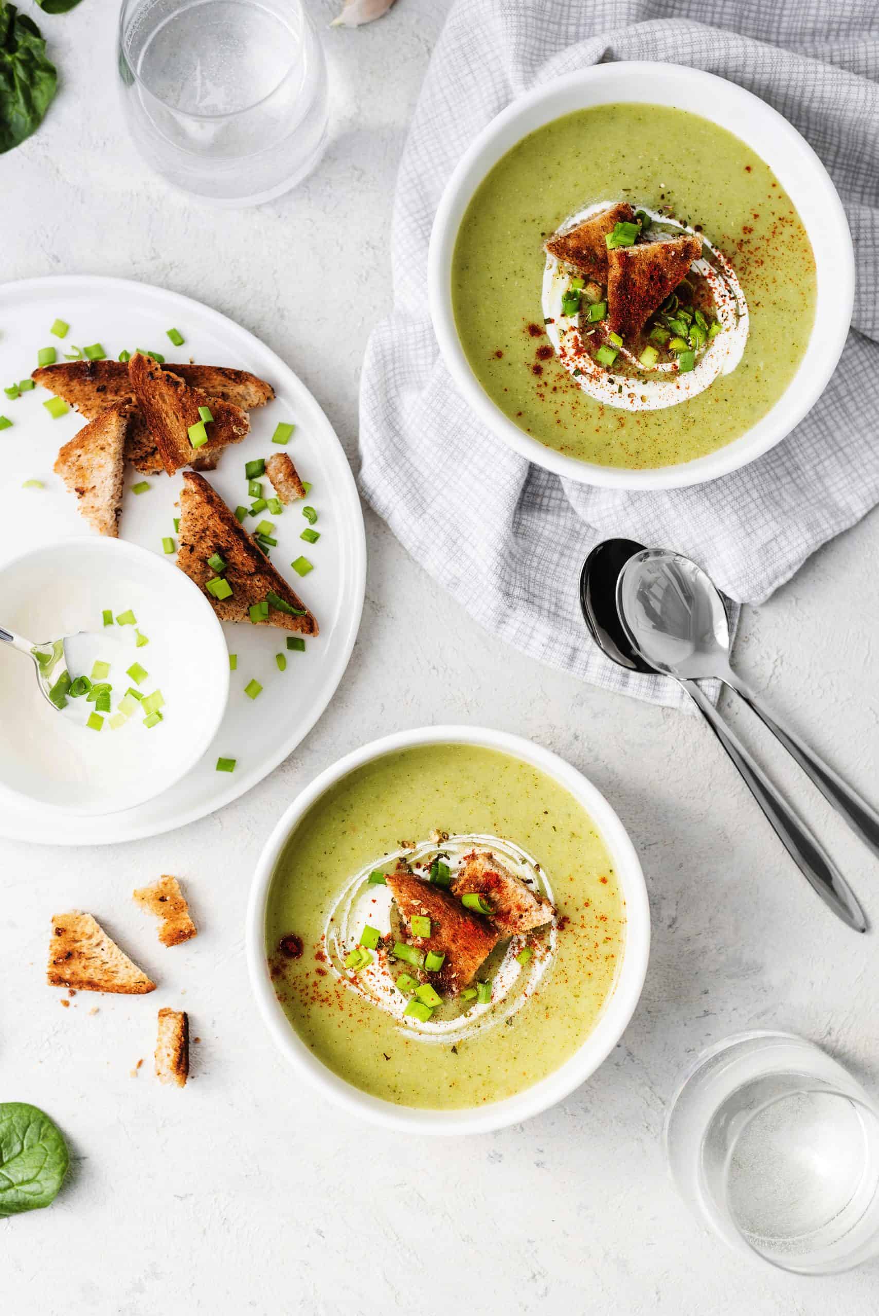 Healthy broccoli cream soup on light stone background. Diet detox food concept. Tasty vegetable soup in white plate